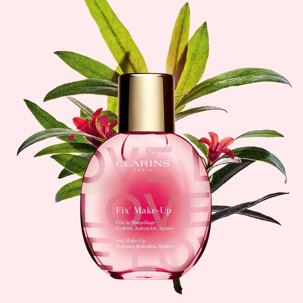 Plan produit du fixateur de maquillage de la collection Love en &eacute;dition limit&eacute;e sur fond rose clair avec rosier des Alpes mettant en valeur l&rsquo;ingr&eacute;dient cl&eacute; du produit