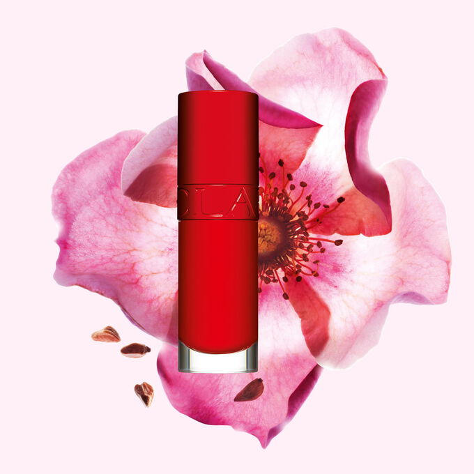 Plan produit de l&rsquo;Huile Confort L&egrave;vres Clarins en teinte Iconic Red avec une rose musqu&eacute;e sur fond rouge et noir.