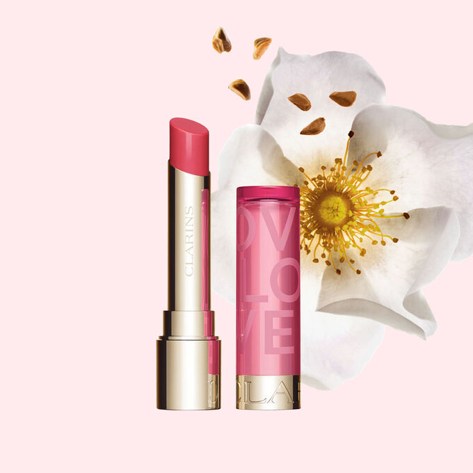 Plan produit du baume &agrave; l&egrave;vres de la collection Love en &eacute;dition limit&eacute;e sur un fond rose clair mettant en valeur la couleur vive du baume &agrave; l&egrave;vres