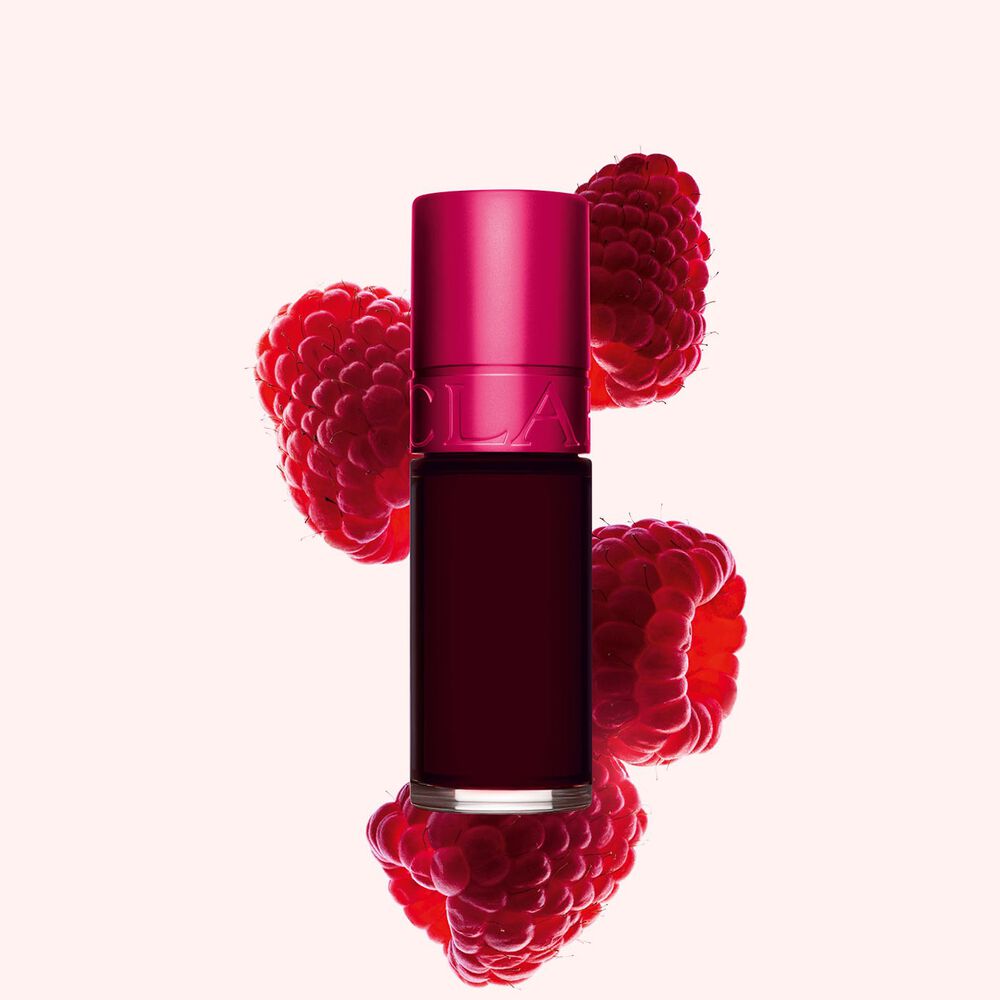 Plan produit de Water Lip Stain Rose de Clarins en teinte 4, à côté de framboises sur fond rose clair.