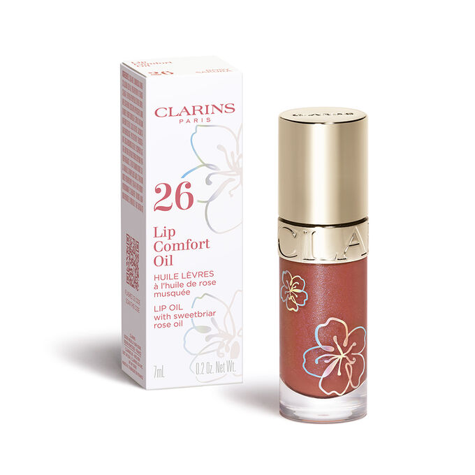 Plan produit de Lip Comfort Oil Clarins, teinte Rosy Sakura, de la gamme Floraison Féerique, et son emballage secondaire.
