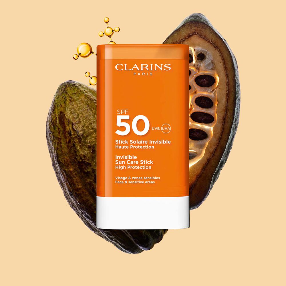 Plan produit du Stick solaire invisible haute protection SPF&nbsp;50 Clarins pour le visage, parmi des mol&eacute;cules de collag&egrave;ne et des f&egrave;ves de cacao.