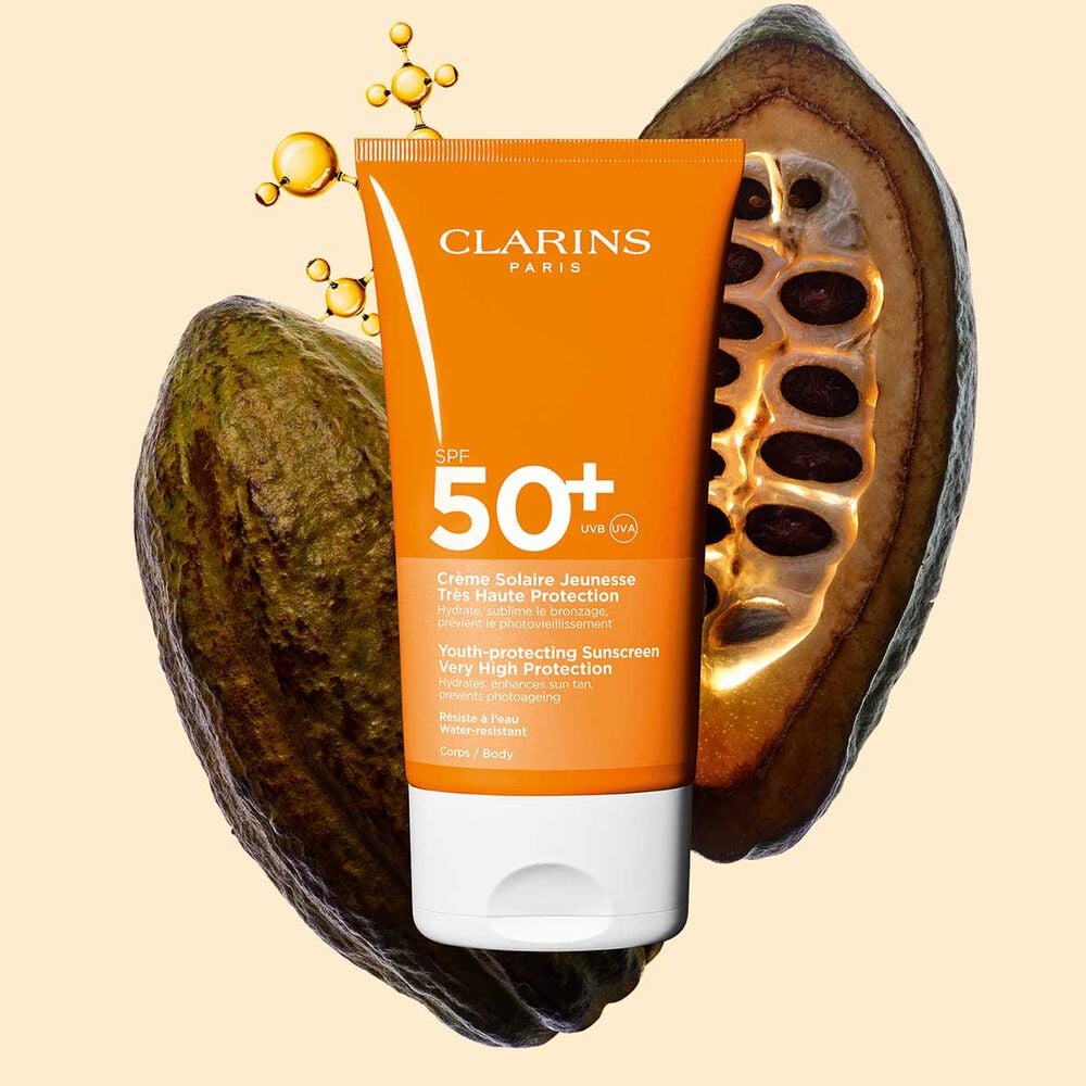 Photo de la Crème solaire anti-âge haute protection SPF 50 Clarins pour le corps, parmi des molécules de collagène et des fèves de cacao.