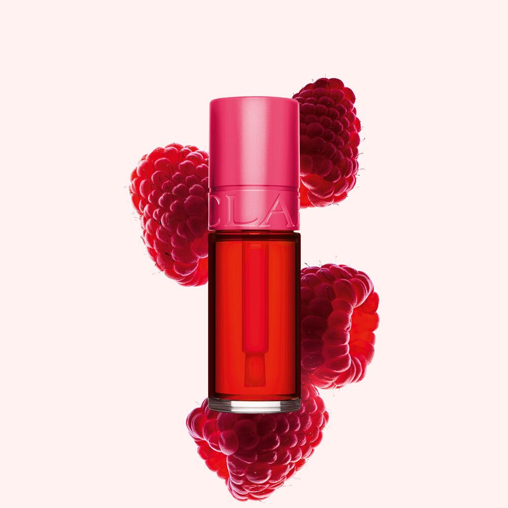 Plan produit de Water Lip Stain Fuchsia de Clarins en teinte 01, à côté de framboises sur fond rose clair.