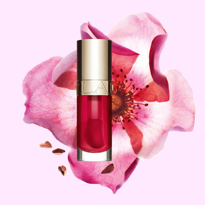 Plan produit de l&rsquo;Huile Confort L&egrave;vres Clarins en teinte Fuchsia avec une rose musqu&eacute;e sur fond couleur rose clair.