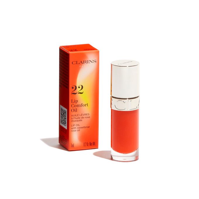 Plan produit de l’Huile Confort Lèvres orange foncé Clarins issue de la collection Pouvoir des Couleurs, présentée avec son emballage