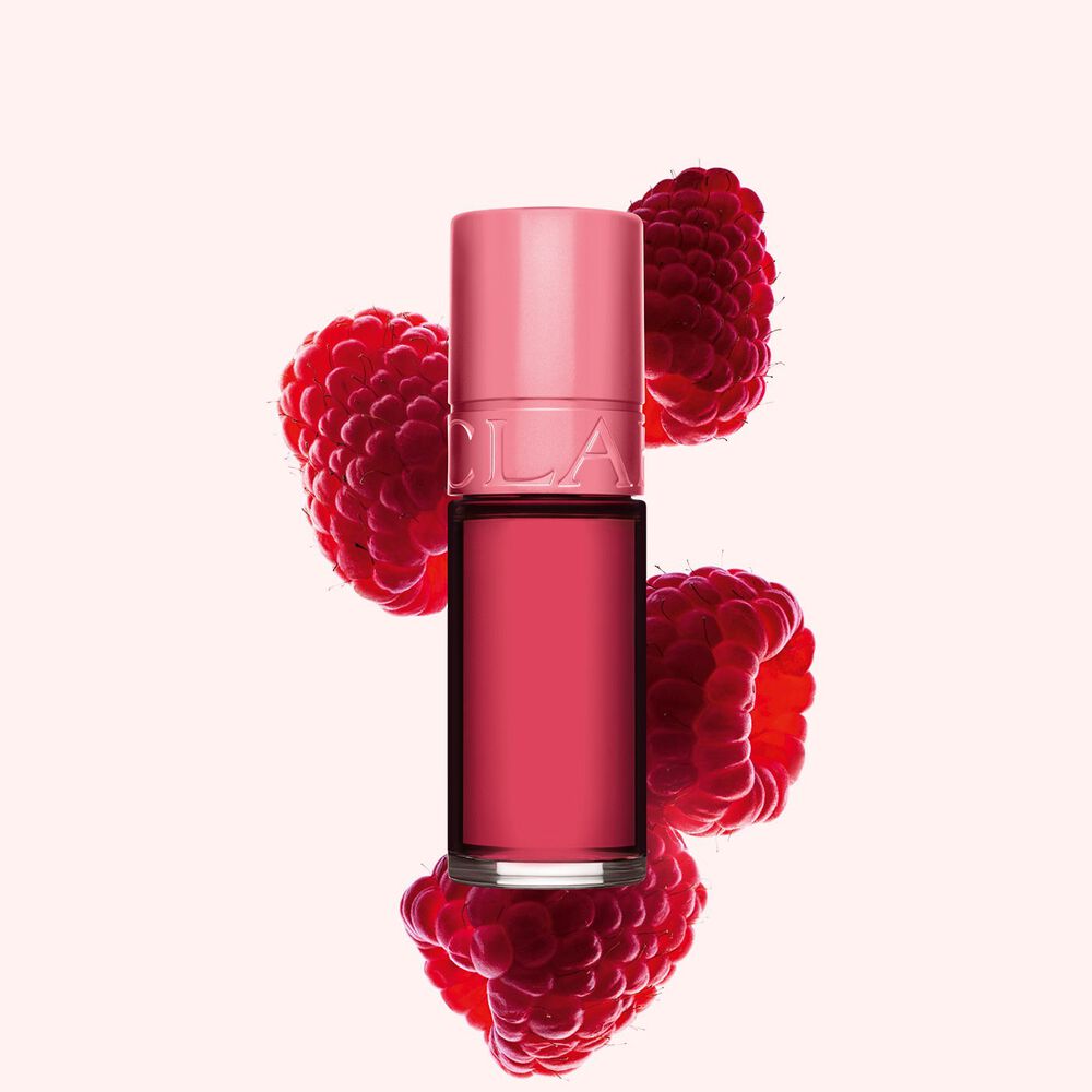 Plan produit de Water Lip Stain Rose de Clarins en teinte 11, à côté de framboises sur fond rose clair.