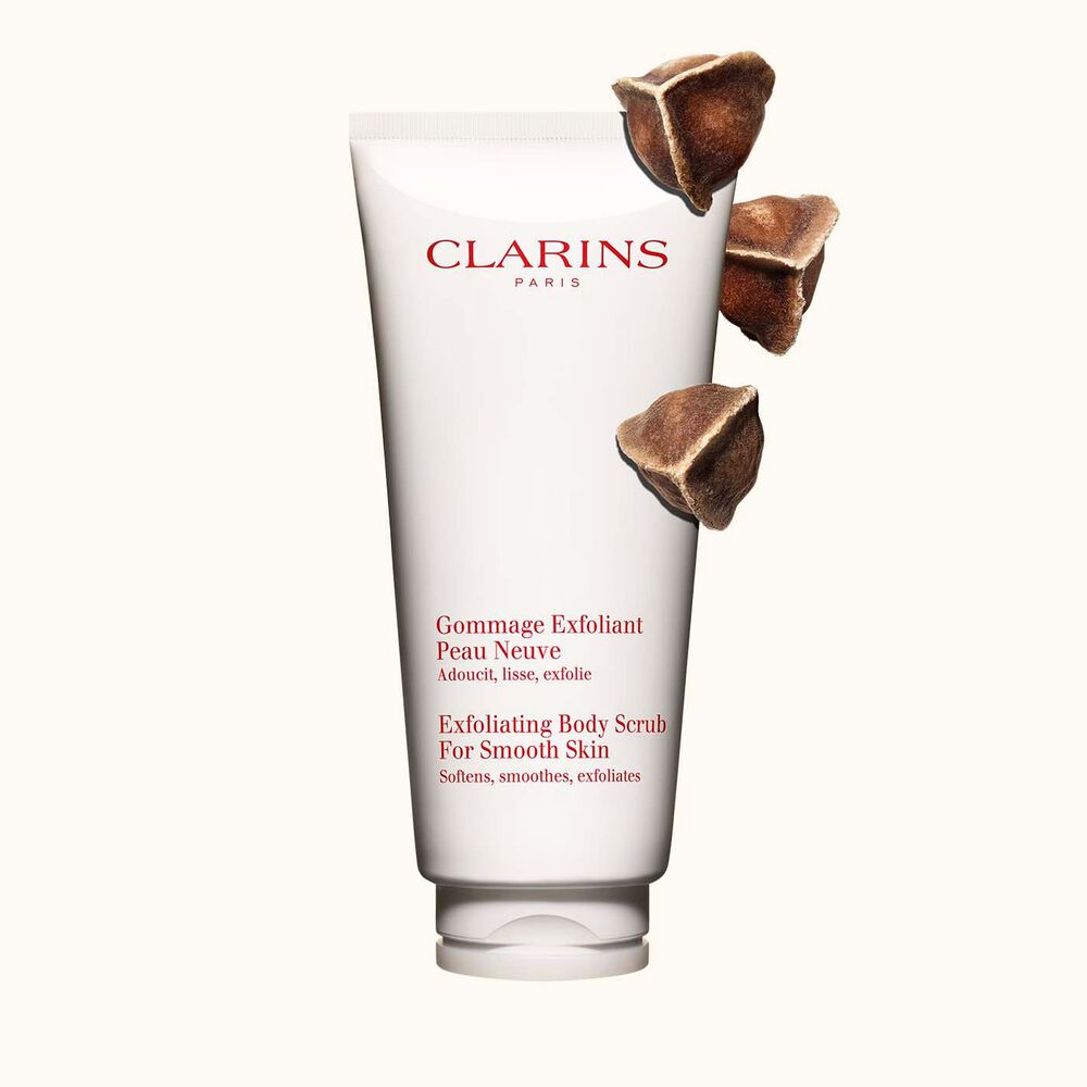 Plan produit du Gommage Exfoliant Peau Neuve de Clarins placé à côté de noix de moringa sur fond beige clair