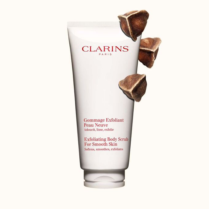 Plan produit du Gommage Exfoliant Peau Neuve de Clarins placé à côté de noix de moringa sur fond beige clair