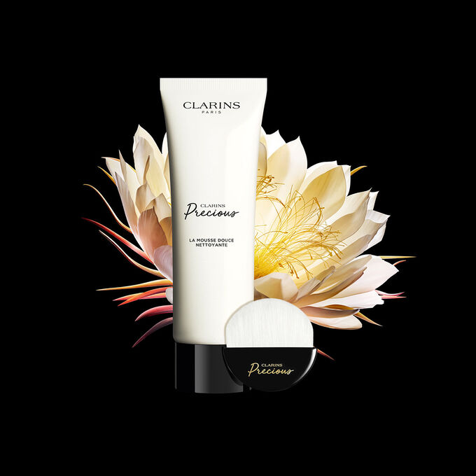 Pr&eacute;sentation de La Mousse Douce Clarins Precious sur fond noir avec une reine de la nuit