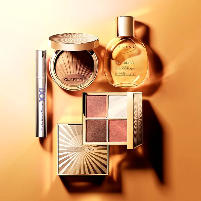 Plan produit des essentiels de l’été de Clarins, avec une palette tout-en-un, une poudre bronzante, un spray fixateur de maquillage et un mascara