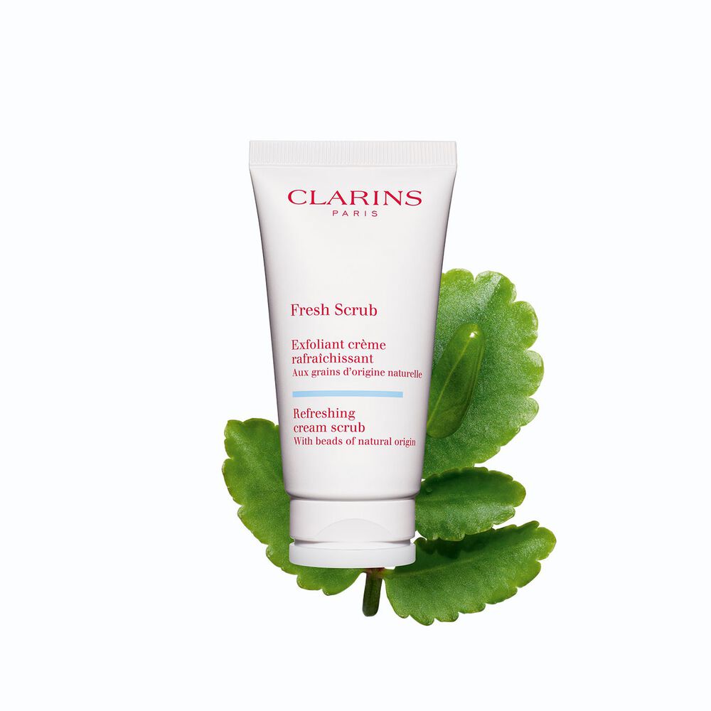 Plan produit de l’exfoliant visage Fresh Scrub à côté de plusieurs kalanchoés sur fond blanc.