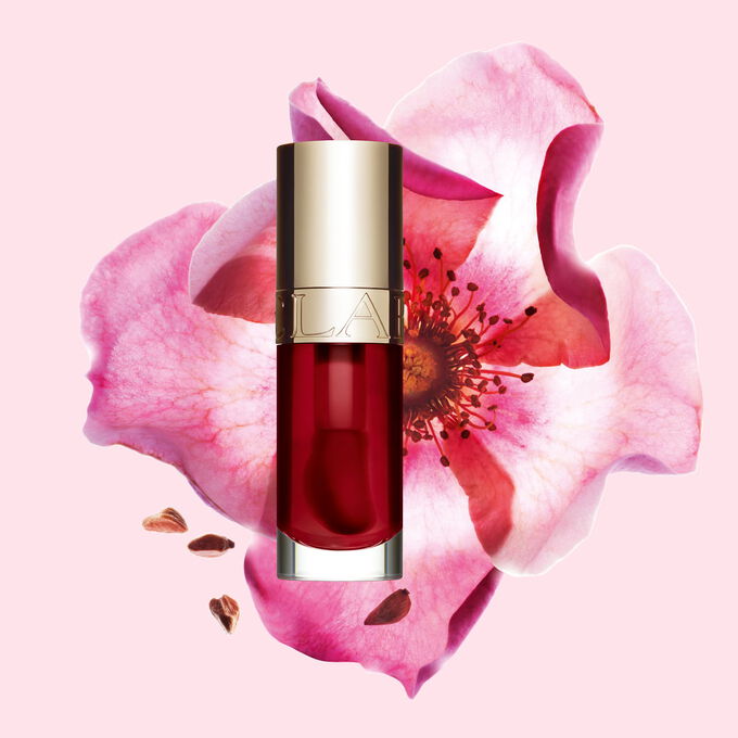 Plan produit de l&rsquo;Huile Confort L&egrave;vres Clarins en teinte Cherry avec une rose musqu&eacute;e sur fond rose clair.