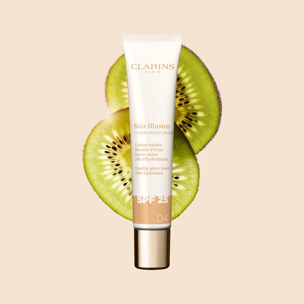 Plan produit du soin Tinted Moisturizer avec SPF pour la teinte de peau moyenne 04, placé à côté de tranches de kiwi sur un fond beige.