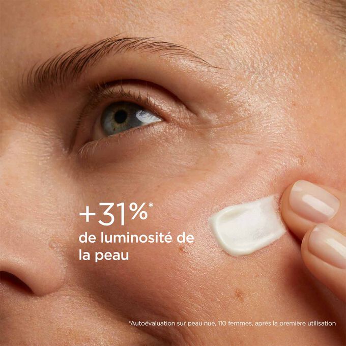 Femme yeux fermés, avec SOS Primer Blanc de Clarins sur le visage pour illustrer qu'il réduit les signes de fatigue de 20%.
