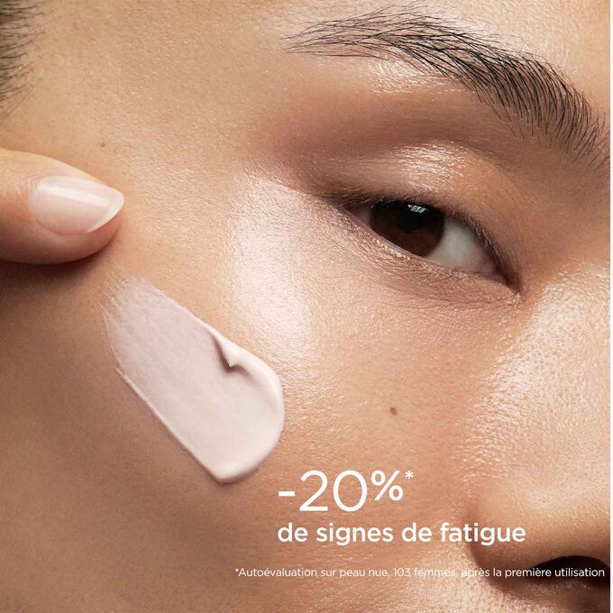 Femme yeux fermés, avec SOS Primer Rose de Clarins sur le visage pour illustrer qu'il réduit les signes de fatigue de 20%.