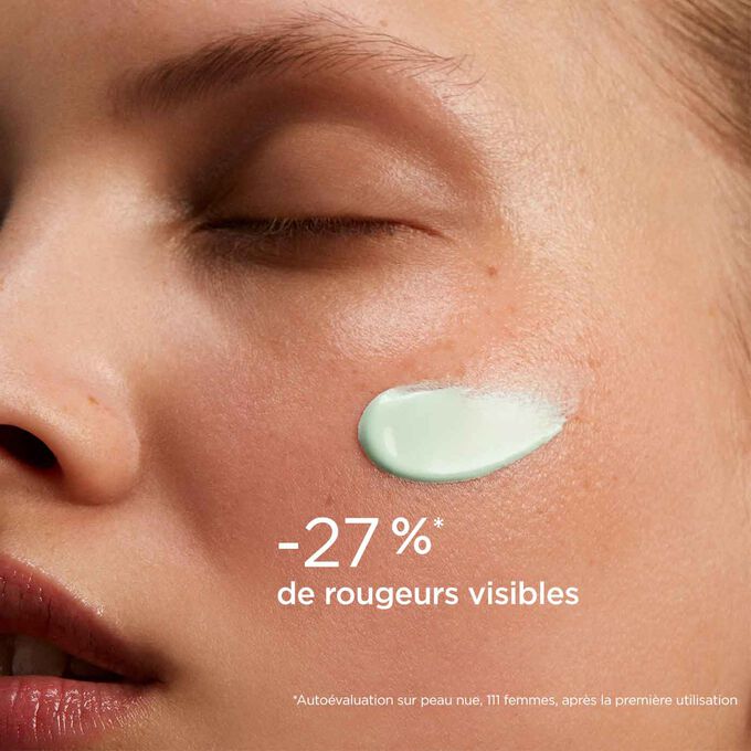 Femme yeux fermés, avec le SOS Primer Vert de Clarins sur le visage pour illustrer qu'il réduit les rougeurs de 27%.