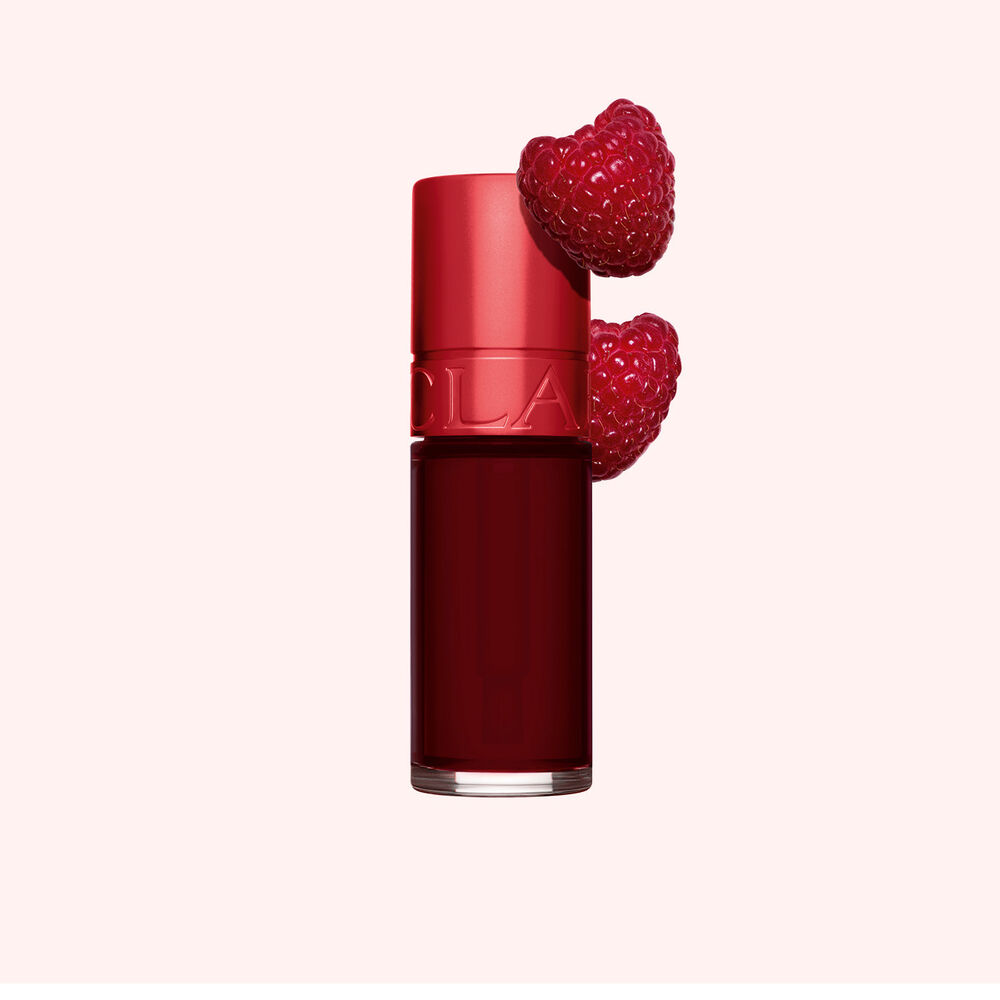 Plan produit de Water Lip Stain Rouge Foncé de Clarins en teinte 9, à côté de framboises sur fond rose clair.