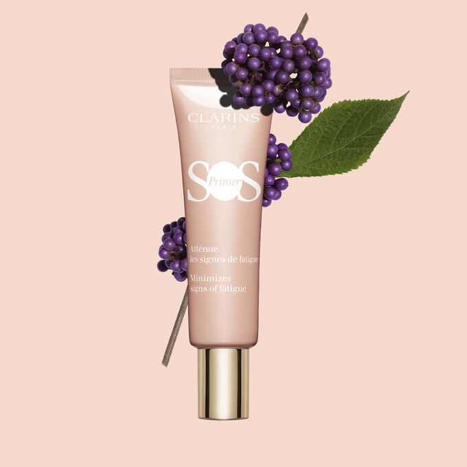 Plan produit d’un tube SOS Primer Rose de Clarins avec des callicarpes, pour réduire la fatigue et renforcer l'éclat.