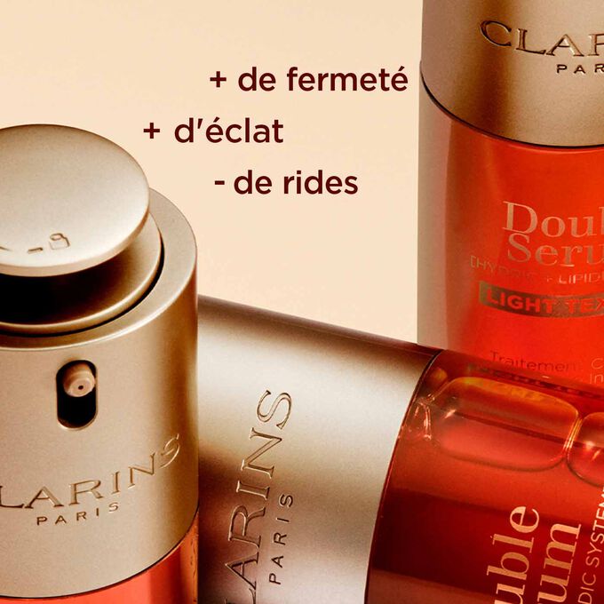 Gros plan sur les flacons du Double Serum Light Texture de Clarins, mettant en valeur la fermeté, l’éclat et la réduction des rides.