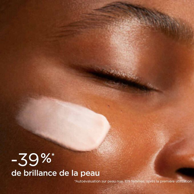 Femme yeux fermés, avec SOS Primer Matifiant Clarins sur le visage illustrant qu'il réduit la brillance de la peau de 39%.