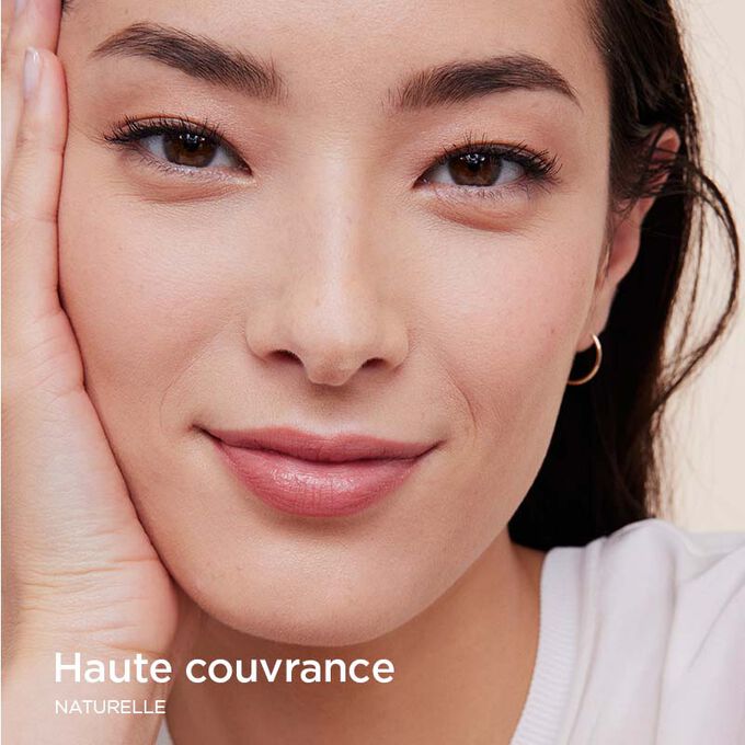 Femme portant le fond de teint Skin Illusion Couvrance Totale de Clarins offrant une couvrance totale et un résultat naturel.