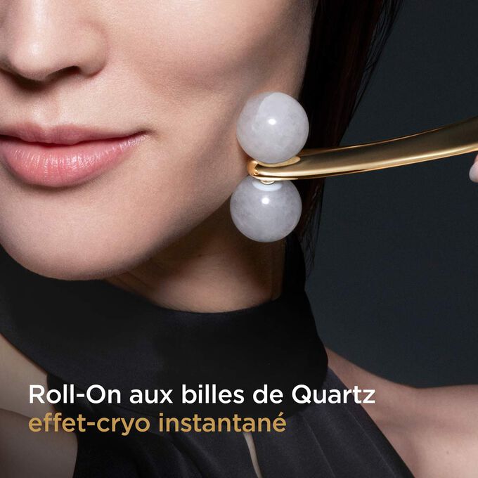 Image d’une femme utilisant le Roll-On Clarins Precious le long de sa mâchoire, mettant en valeur l’effet cryo-tonifiant instantané du roller de quartz