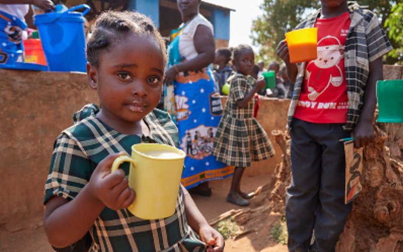 Photographie illustrant le partenariat avec Mary’s Meals, qui offre des repas scolaires ayant un impact positif sur la vie des enfants de certaines des communautés les plus pauvres du monde, avec un gros plan sur un enfant tenant une tasse.