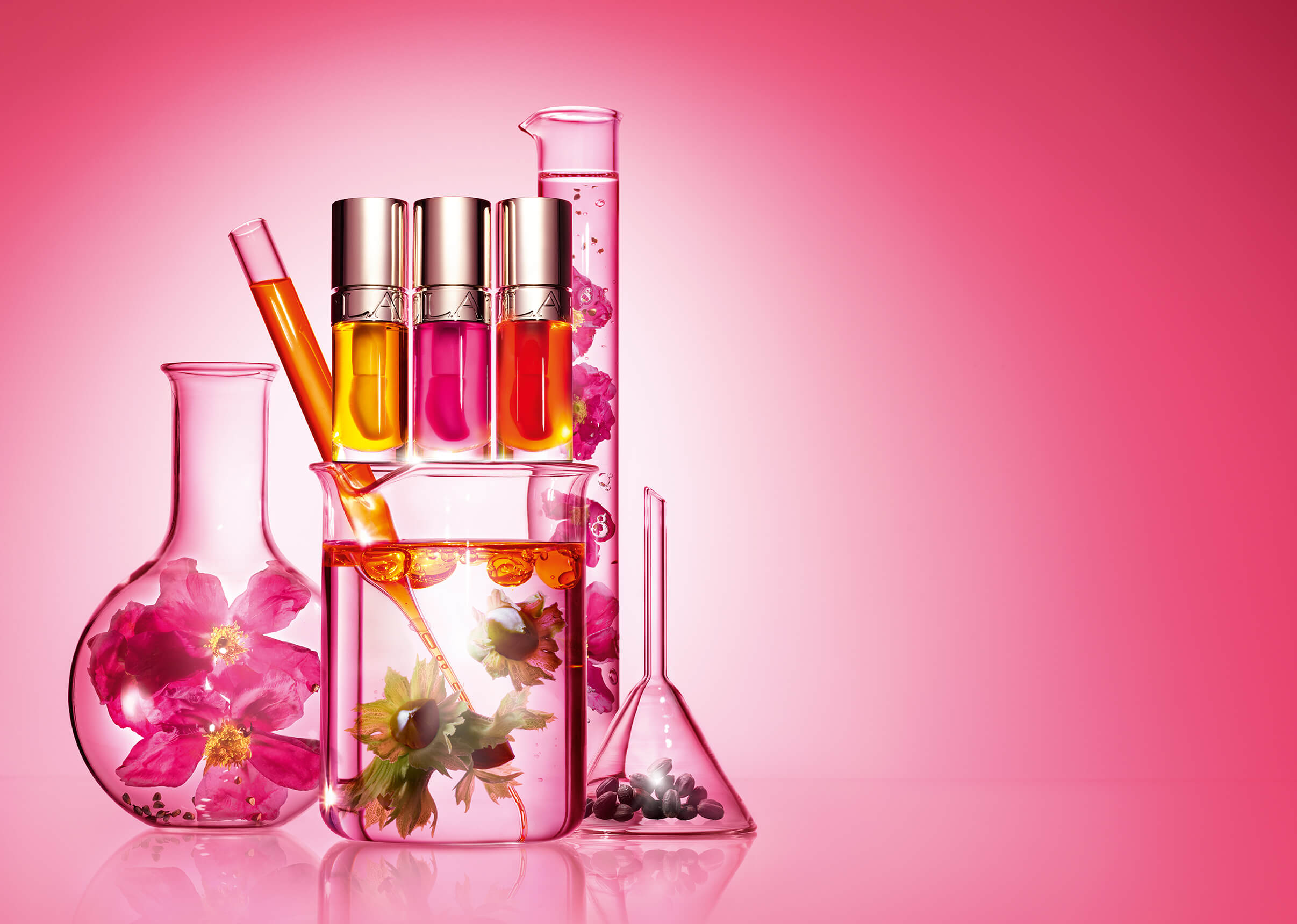 Plan produit Huile Confort Lèvres entouré de récipients de laboratoire en verre